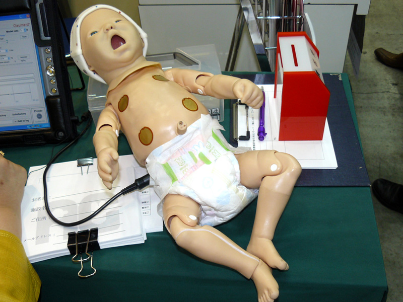 新生児ロボット。頭の横にあるのが、コントロール用のハンドヘルドPC