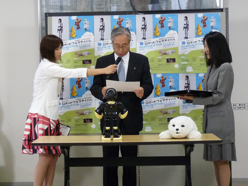 【写真18】任命状を読み上げる犬島JRF会長と、それを聞いている? MANOI君