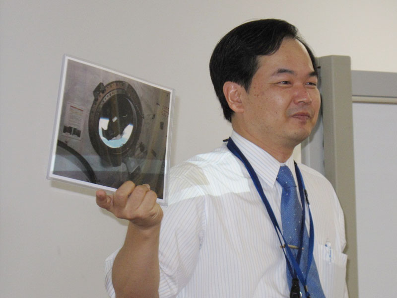 山本郁夫教授。手にしているのは若田宇宙飛行士が国際宇宙ステーションに持っていったエイ型ロボットの写真