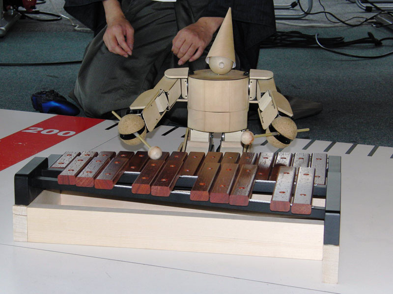 『サイコロサッカー』と『キューブ』の間の休み時間にはデモンストレーションが。小田利延氏のロボット『Kinopy』が腕を上げた木琴で、お台場の等身大の例のロボのテーマ曲を披露