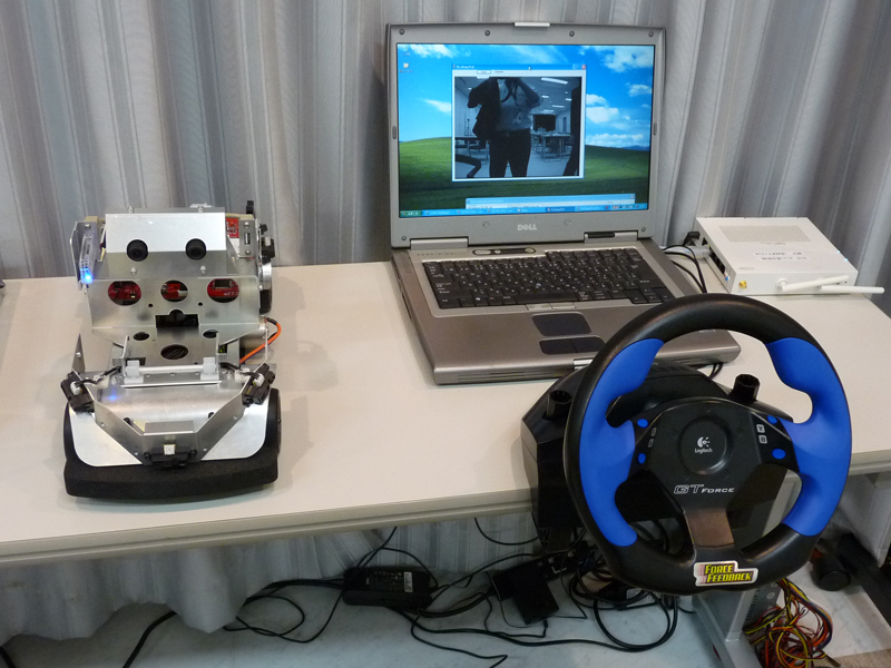 【写真32】首都大学東京山口研究室とゼットエムピーによる共同研究。RoboCarに搭載した視認用カメラから映像を送信し、それをモニターに映しながら無線LAN経由で運転を行なう