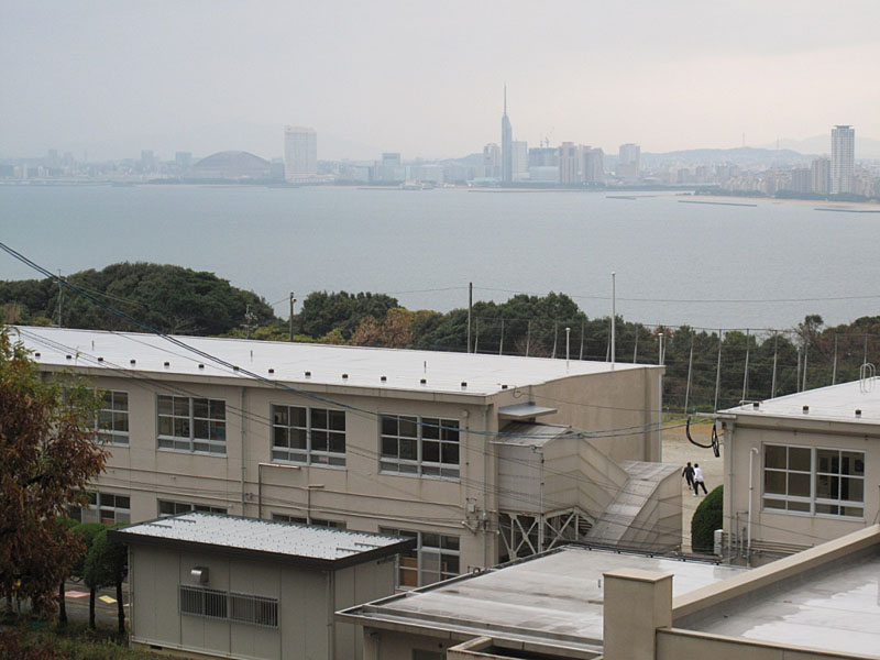 能古島小学校校舎越に見る福岡市街地。福岡ヤフードームや福岡タワーが見える