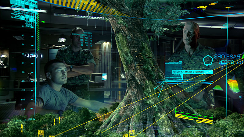 ホームツリーの3D映像の前で軍人たちに情報提供をするジェイク。ツリーの右にいるのがクォリッチ大佐