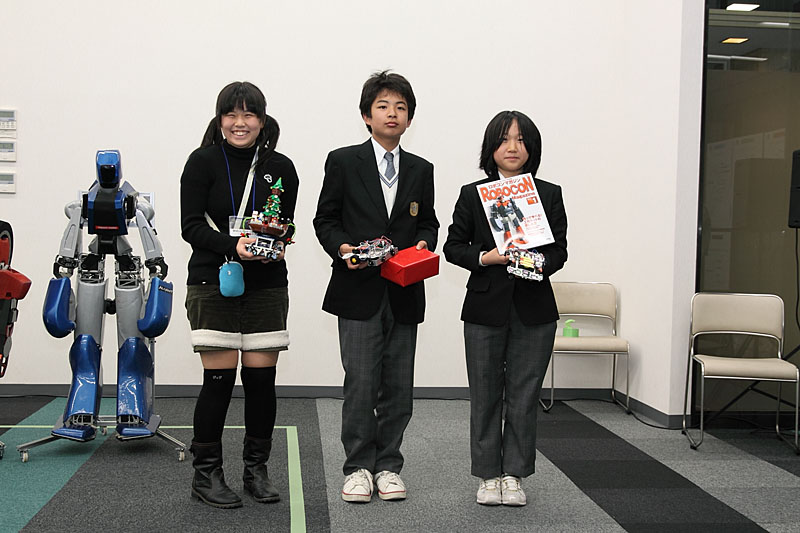 中学生部門の記念撮影。左から3位のヴィーさん、優勝のロボット5号の製作者、芙蓉の製作者